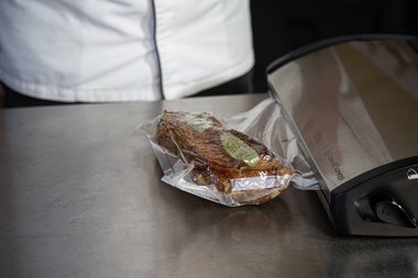 Mettere la carne di vitello sottovuoto con gli aromi e le spezie.
